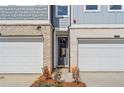 Charming townhome exterior showing a gray door flanked by two garage doors at 1024 Rose Dr, Marietta, GA 30060