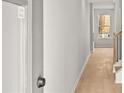 Clean hallway showcasing a window, door, neutral paint, and carpeted floors leading to the next area at 1024 Rose Dr, Marietta, GA 30060
