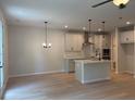 Spacious living room with light wood flooring, modern lighting, and a kitchen island at 1024 Rose Dr, Marietta, GA 30060