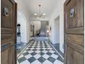 Grand foyer featuring a checkered tile floor, chandelier, archway, and ornate front doors at 388 Beverly Ne Rd, Atlanta, GA 30309