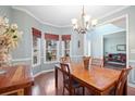 Charming dining room with hardwood floors, a bay window, decorative trim, and a stylish chandelier at 69 New Brunswick Ct, Suwanee, GA 30024