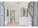 Bright foyer featuring hardwood floors, staircase, elegant lighting, and mirror accent at 1590 Greyson Rdg, Marietta, GA 30062