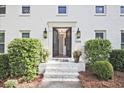 Inviting front entrance with black double doors, classic sconces, and landscaped greenery at 1590 Greyson Rdg, Marietta, GA 30062