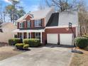 Brick house with well-kept lawn, two-car garage, basketball hoop, and trimmed hedges at 3595 Ansley Park Dr, Suwanee, GA 30024