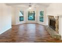 Bright living room with fireplace, large windows, hardwood floors and a ceiling fan at 4396 Shelley Nw Ln, Lilburn, GA 30047