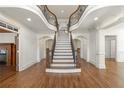 Grand foyer featuring a staircase with iron spindles, hardwood floors, and elegant architectural details at 2480 Flint Creek Dr, Cumming, GA 30041