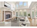 Bright living room with fireplace, large windows, and a plush white sofa creating a cozy atmosphere at 2480 Flint Creek Dr, Cumming, GA 30041