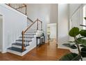 Bright foyer with hardwood floors, a staircase with white railings, and view to dining room at 2607 Westchester Se Pkwy, Conyers, GA 30013