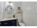 Stylish powder room featuring designer wallpaper, modern vanity, and elegant gold fixtures at 2607 Westchester Se Pkwy, Conyers, GA 30013