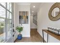 Bright and airy foyer with hardwood floors, an elegant mirror, a plant, and staircase access at 347 Bailey Walk, Alpharetta, GA 30009