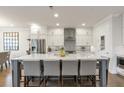 Modern kitchen featuring white cabinets, stainless steel appliances, large center island with breakfast bar, and hardwood floors at 347 Bailey Walk, Alpharetta, GA 30009