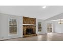 Cozy living room with a striking stone fireplace, white walls, and lots of natural light at 815 Oxford Hall Dr, Lawrenceville, GA 30044