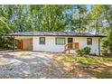Inviting single-story house with a carport, freshly painted white exterior, and green surroundings at 3113 Bellgreen Way, Decatur, GA 30032