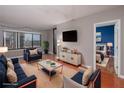View of a stylish, staged living room with modern furnishings, hardwood floors, and bedroom in the background at 3481 Lakeside Ne Dr # 1705, Atlanta, GA 30326