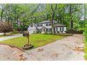 Traditional two-story home with a well-manicured lawn and mature trees at 3900 Millwood Lane Nw, Lilburn, GA 30047