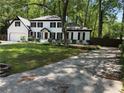Two story traditional home with attached garage and manicured front lawn and driveway at 3900 Millwood Lane Nw, Lilburn, GA 30047