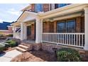 Inviting front porch with stone accents, white pillars, and a charming, covered entry enhancing the home's curb appeal at 4978 Millwood Dr, Canton, GA 30114