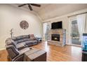 Living room features a cozy stone fireplace, hardwood floors, ceiling fan, and a large sectional sofa at 9369 Kraft Dr, Winston, GA 30187