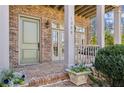 Inviting brick front porch with porch swing and planters, perfect for relaxing at 1059 Hedge Rose Ne Ct, Atlanta, GA 30324