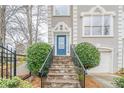 Home's entryway featuring a stone staircase, iron railing, a blue front door, and manicured bushes at 2426 Vivian Cir, Decatur, GA 30030