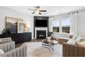 Relaxing living room features a cozy fireplace, large windows for natural light, and stylish modern furniture at 1475 Park Lane Ln, Fairburn, GA 30213