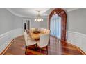 Formal dining room with hardwood floors, wainscoting, and decorative window treatment at 3460 Mansions Pkwy, Berkeley Lake, GA 30096