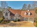 Charming two-story house with an attached three-car garage, complemented by lush landscaping and well-maintained lawn at 3460 Mansions Pkwy, Berkeley Lake, GA 30096