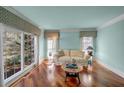 Cozy living room with hardwood floors, light blue walls, and large windows overlooking greenery at 3460 Mansions Pkwy, Berkeley Lake, GA 30096