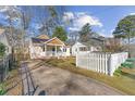 Quaint home with an inviting exterior, a long driveway, and a white picket fence at 633 Mckoy St, Decatur, GA 30030