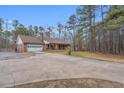 Wide view of home with a long driveway and a covered porch, set against a wooded backdrop at 6890 Cedar Mountain Rd, Douglasville, GA 30134