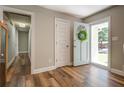 Bright foyer showcasing wood floors, neutral walls, and a view into the hallway at 411 Burke Cir, Mcdonough, GA 30253