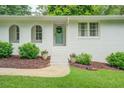 Inviting entrance with a decorated door, white brick, and beautiful landscaping at 411 Burke Cir, Mcdonough, GA 30253