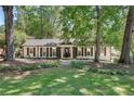 Charming single-story home with white brick, brown trim, well-manicured lawn, and stone walkway at 4159 King Valley Se Dr, Smyrna, GA 30082