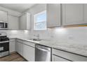 Modern kitchen with white cabinets, granite countertops, stainless steel appliances, and tiled backsplash at 159 Park Lane Ln, Fairburn, GA 30213