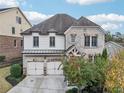 Striking exterior showcasing a two-story home with a two-car garage and professionally designed landscaping at 11760 Stratham Dr, Alpharetta, GA 30009