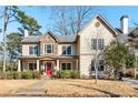 Charming two-story home with neutral siding, stone accents, a bright red door, and covered front porch at 2217 Virginia Ne Pl, Atlanta, GA 30305