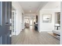 Inviting foyer with light wood flooring, wainscoting, and a glimpse into the home's open-concept living spaces at 5955 Misty Hill Ln, Buford, GA 30518