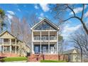 Charming two-story home with a double porch and brick foundation on a grassy lawn at 2395 Saint James Nw Dr, Atlanta, GA 30318