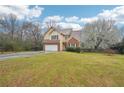 Well-kept home featuring a two-car garage, green lawn, and a brick and tan exterior at 381 Gates Mil Dr, Lawrenceville, GA 30045