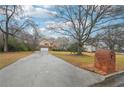 View of a two-story home with a large front yard, long driveway, and brick mailbox at street at 381 Gates Mil Dr, Lawrenceville, GA 30045