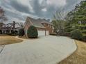 Spacious driveway leading to a three-car garage, adjacent to a manicured lawn and treelined property at 1320 Kildare Ct, Snellville, GA 30078