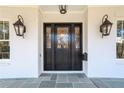 A stately front door flanked by lantern sconces, creating an inviting entrance with bluestone porch at 18 Polo Ne Dr, Atlanta, GA 30309