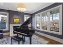 Elegant music room with a grand piano, fireplace, and large windows providing natural light at 18 Polo Ne Dr, Atlanta, GA 30309