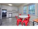 Eat-in kitchen with stainless appliances, bright white cabinetry, and trendy light gray flooring at 2493 Cherie Glen Trl, Snellville, GA 30039