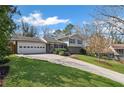 Attractive home with a long driveway, lush green grass, and neighboring house at 260 Mansell Cir, Roswell, GA 30075