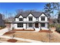 Charming two-story home featuring a modern design, dark framed windows, and professionally landscaped front yard at 320 Dodd Ln, Alpharetta, GA 30005