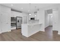 Bright kitchen with white cabinets, stainless steel appliances, and laminate wood flooring at , Mcdonough, GA 30253