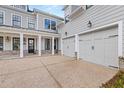 Spacious driveway that leads to a two-car garage, with gray siding and a covered porch at 1005 Coleman Place Dr, Roswell, GA 30075