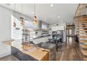 Modern kitchen with custom lighting, an island bar, wood floors and open floating stairs to a second level at 560 John Wesley Dobbs Ave, Atlanta, GA 30312