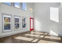 Bright living room with large windows, wood floors, and a red door leading to the entryway at 560 John Wesley Dobbs Ave, Atlanta, GA 30312